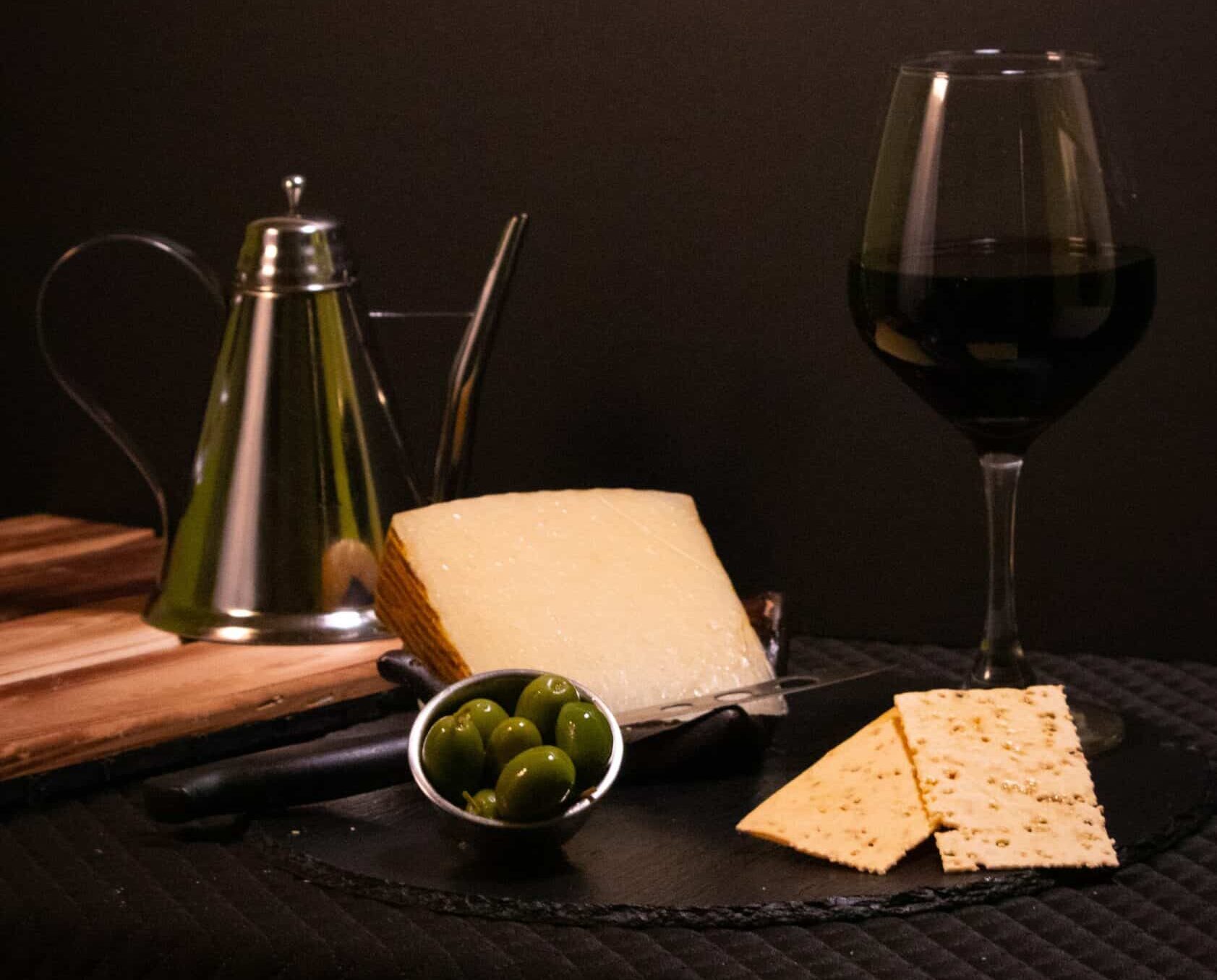 Manchego Cheese served with wine & olives