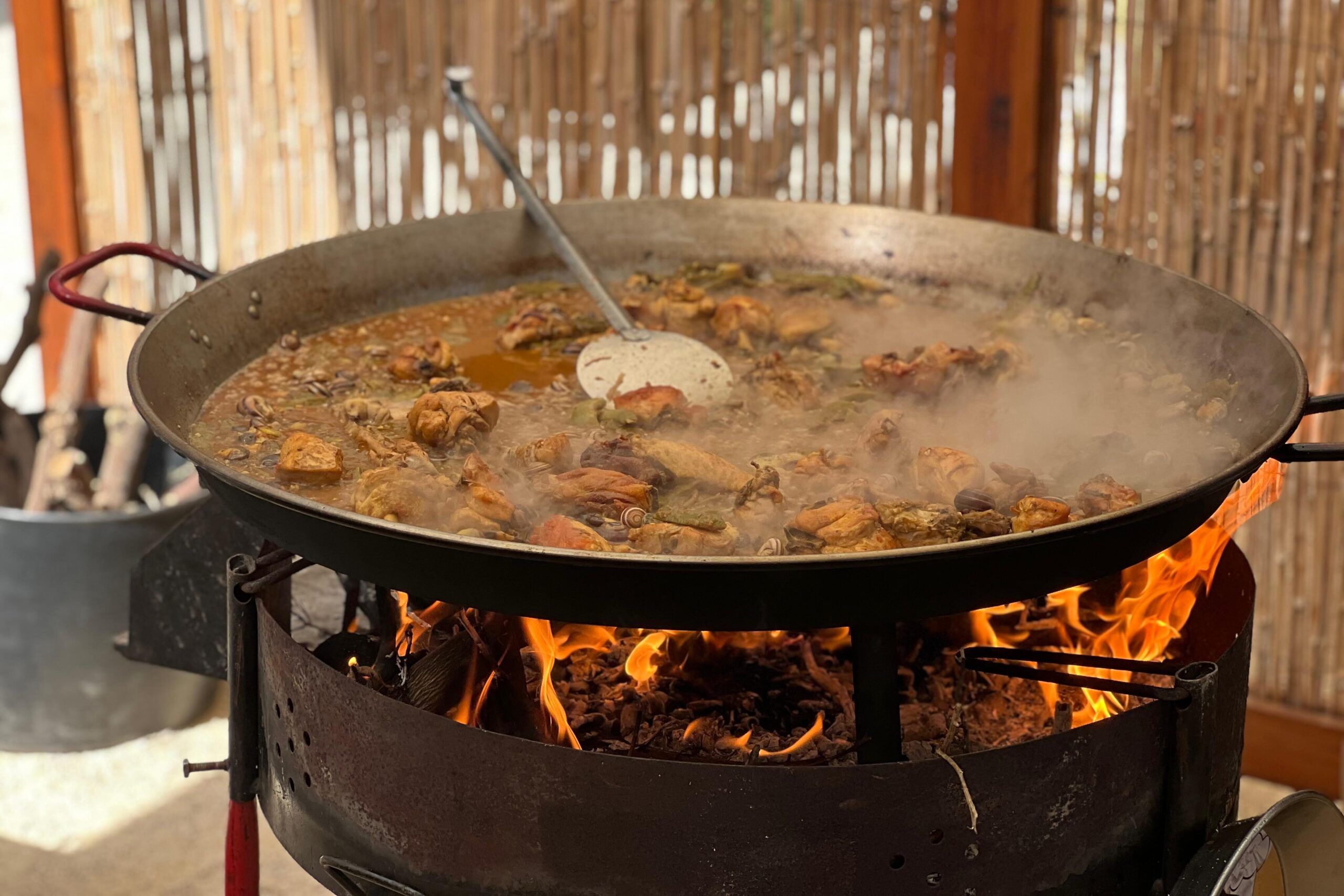 Traditional paella Valenciana cooking over a wood fire in Sueca, Valencia.